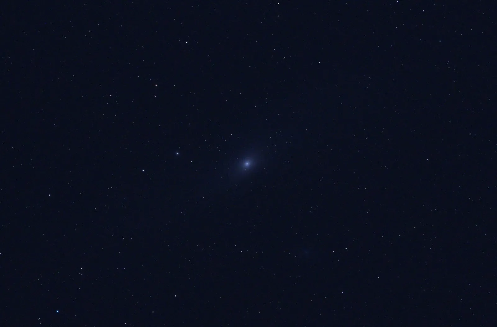 A single raw photo of the Andromeda Galaxy, mostly dark blue sky with a faint smudge in the middle